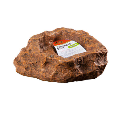 Brown, rock-textured Zilla Terraced Dish (Medium) with a white and green label visible inside, angled slightly from above.