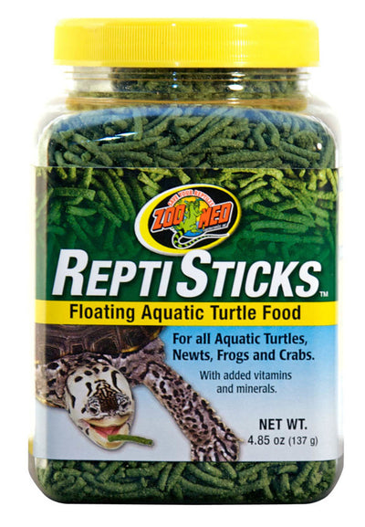 Clear jar of Zoo Med Reptisticks, green floating food for aquatic turtles, newts, frogs, and crabs, with a yellow lid.