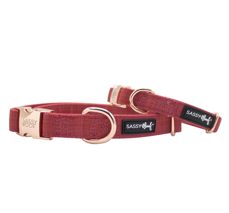 Burgundy Sassy Woof dog collar with rose-gold-tone hardware and black logo labels