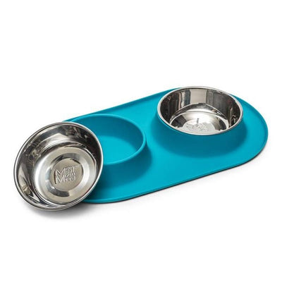 Teal silicone feeding mat holds two stainless bowls, one bowl removed and tilted