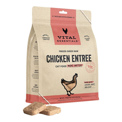 A standing bag of Vital Essentials freeze-dried chicken cat food with two brown patties in front.
