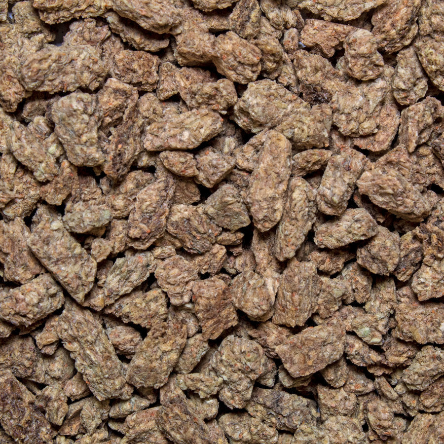 Close-up of brown, irregularly shaped freeze-dried brine shrimp pieces, showing varied textures and some reddish specks.