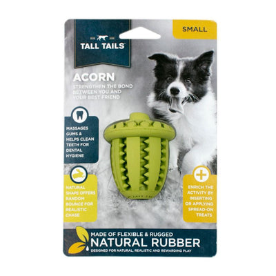 Packaged Tall Tails Natural Rubber Acorn dog toy, green, with a black and white dog in the background.