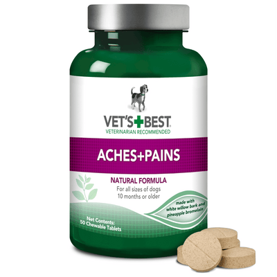 Green bottle of Vet's Best Aches+Pains dog supplements with a few tan chewable tablets spilled out.