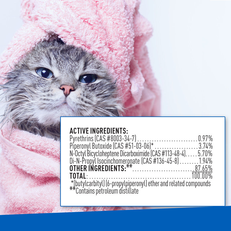 Wet cat wrapped in a pink towel beside the ingredients panel