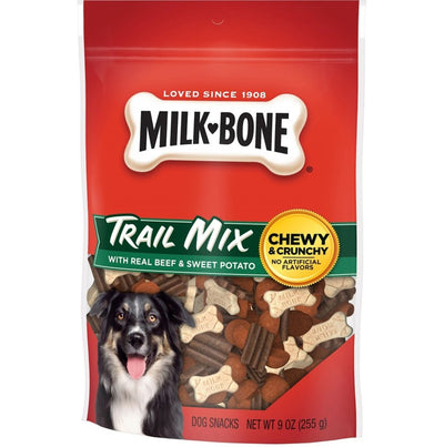 Milk-Bone Trail Mix bag filled with beef biscuits and jerky-style pieces, dog pictured