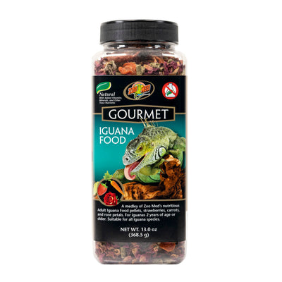 Clear plastic jar of Zoo Med Gourmet Iguana Food with a black label featuring an iguana, strawberries, carrots, and rose peta