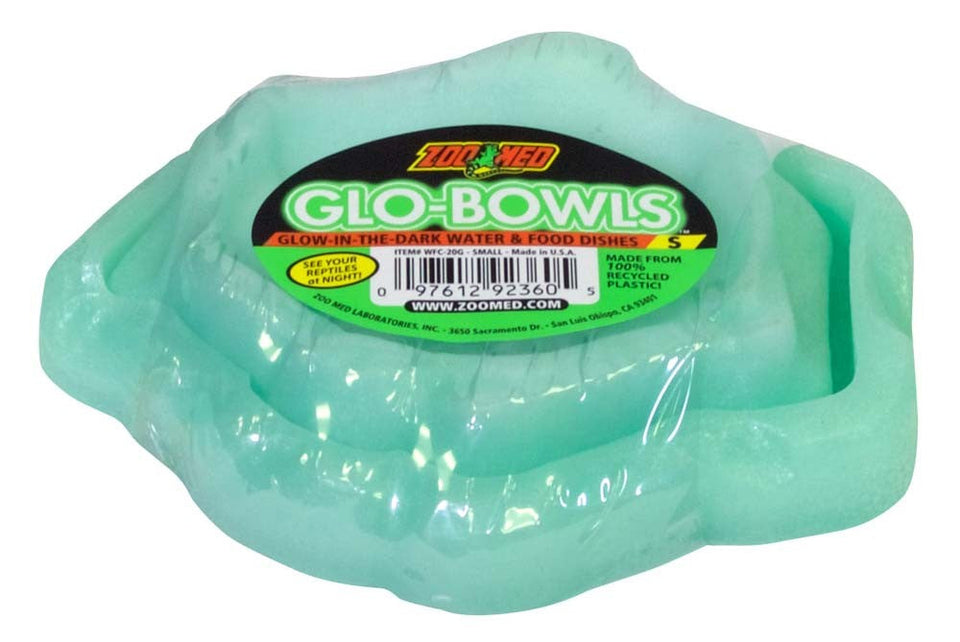 Small green glow-in-the-dark pet food and water bowls in clear plastic packaging, viewed from above.