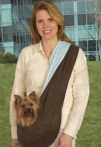 Woman outdoors carrying small dog in brown and light blue ESC Reversible Sling Pet Carrier across her chest