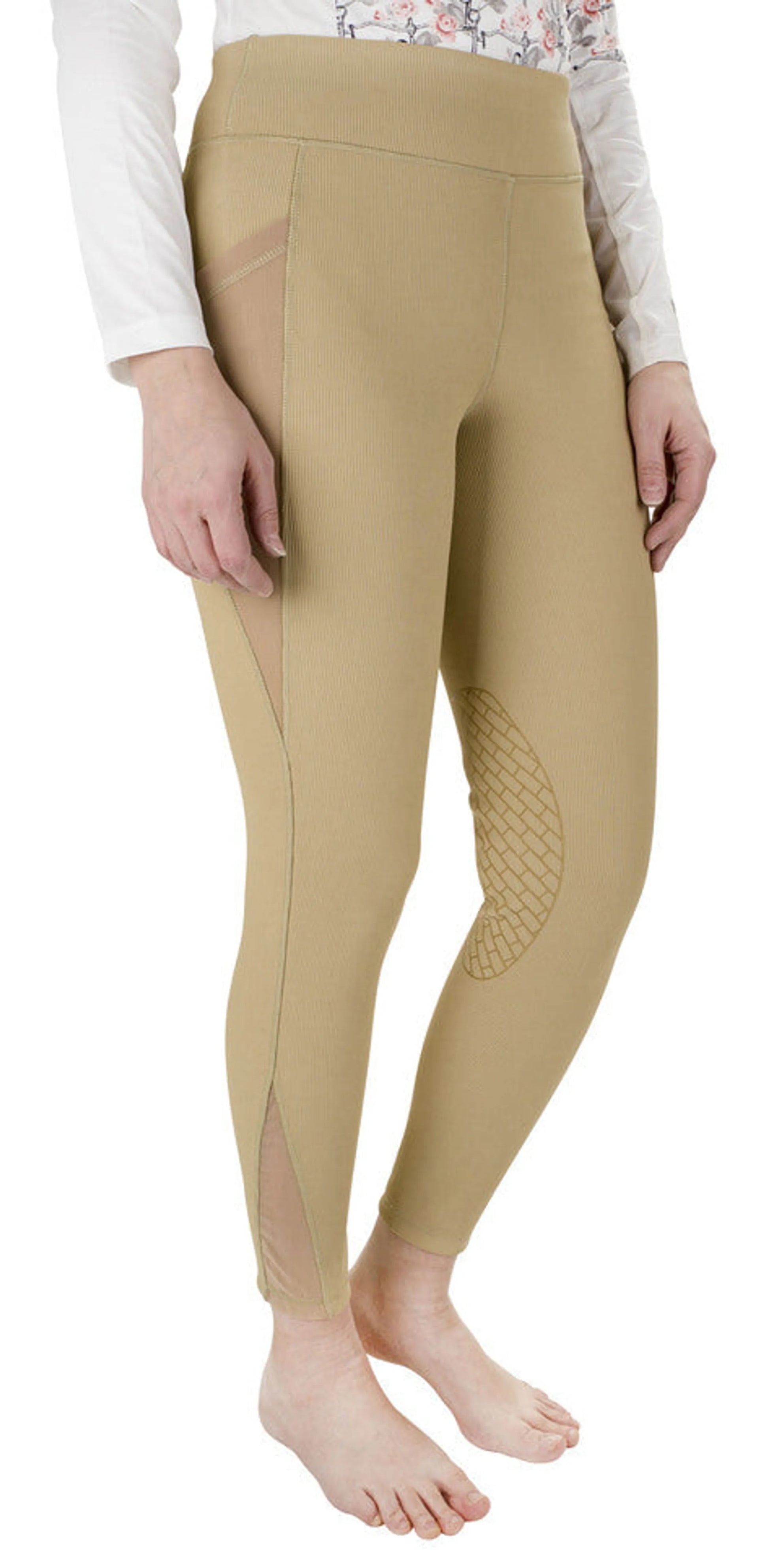 Woman wearing beige TUFFRIDER LADIES CLASSIC RIBBED TIGHTS with textured grip panels and mesh inserts on calves.