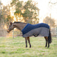 Horse wearing TuffRider Hybrid Standard Neck Cooler-Navy/Gray-69 standing in a grassy paddock at sunset