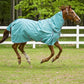Horse wearing TuffRider 1200D Winter Comfy Detachable Neck Sheet in a green pasture with white fence.