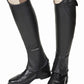 Close-up of a person wearing black TuffRider Ladies Belmont Leather Half Chaps over riding boots with beige riding pants.