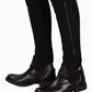 TuffRider Adult Grippy Nubuck Half Chaps in black worn over riding boots on tan riding pants.