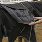 Black waterproof horse blanket showing inner lining held open by person, TuffRider 4-in-1 Waterproof All Season Blanket