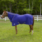 Brown horse wearing a blue Tuffrider Cooler Sheet Combo standing on grass near white fence and trees