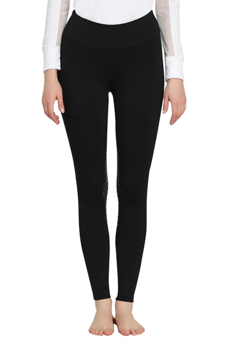 Woman wearing black TuffRider Ladies Bootie Tights With Pocket, standing barefoot in front of white background