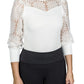 Woman wearing Spicy Girl Sage Long Sleeve Shirt by EC- White- L with floral lace sleeves and solid bodice tucked into black pants