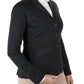 Woman wearing a fitted black Equine Couture Ladies Ultra Light Show Coat with beige riding pants on white background