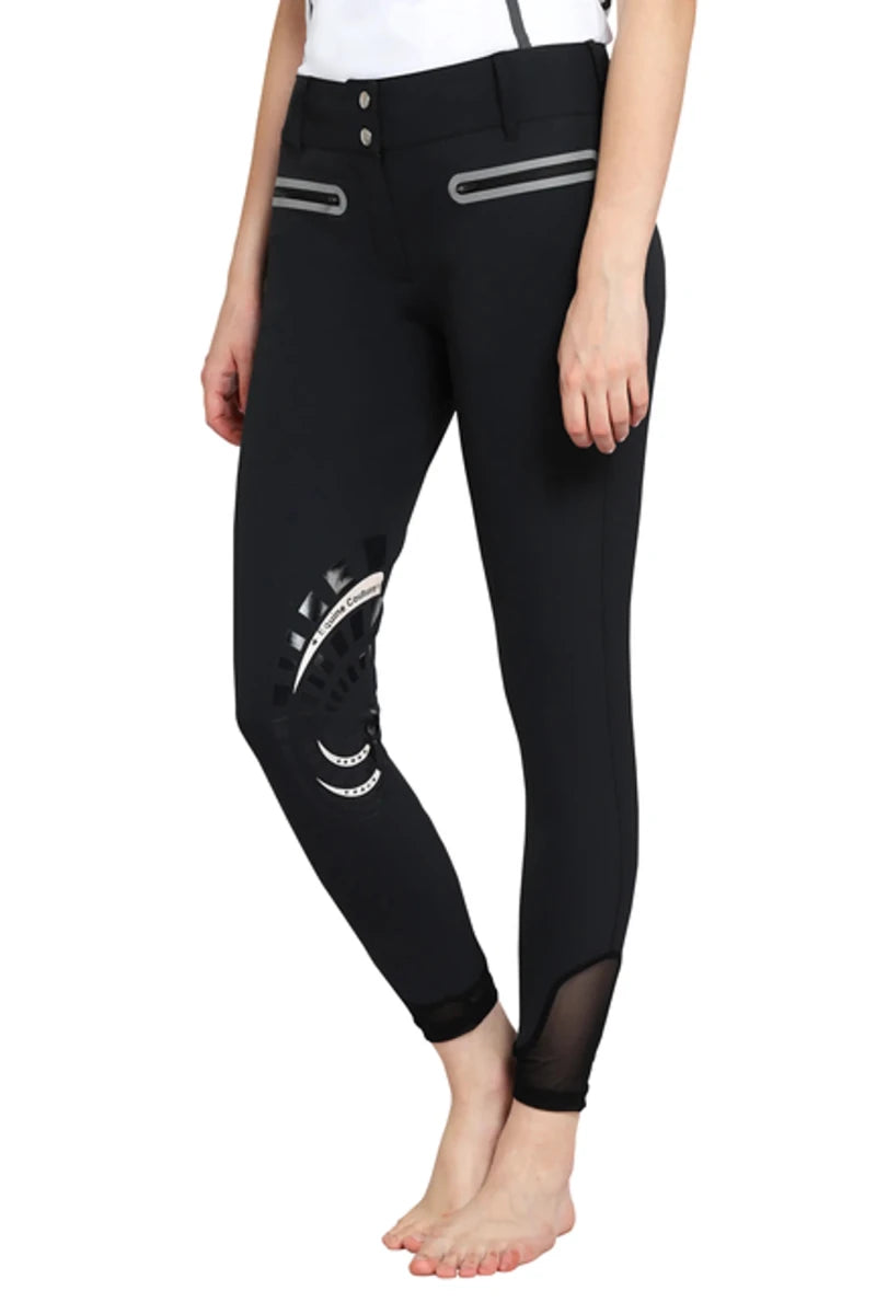 Model wearing black EQUINE COUTURE LADIES IBIZA KNEE PATCH BREECHES with detailed knee patches and mesh ankle panels.