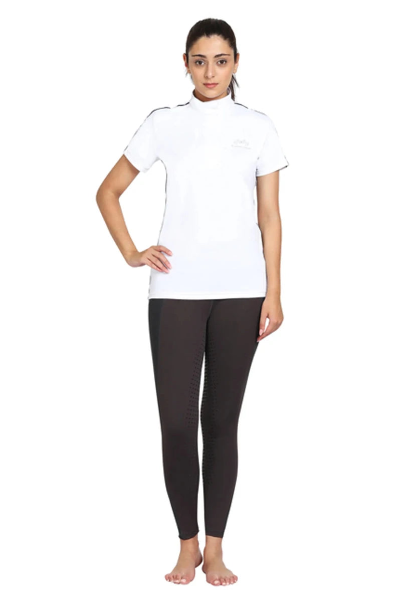 Woman wearing white EQUINE COUTURE LADIES ELIANA SHORT SLEEVE SHOW SHIRT with black riding pants standing barefoot
