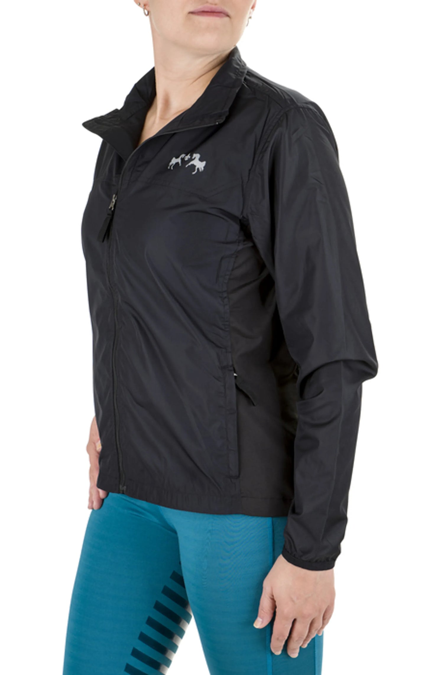 Woman wearing a black Equine Couture Ladies Aberdeen Jacket with horse logo and blue riding pants in white background.