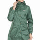 Woman wearing a green Equine Couture Element Rain Jacket with hood and front pockets in a relaxed pose