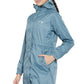 Woman wearing a blue Equine Couture Element Rain Jacket with hood and pockets, styled for equestrian use.