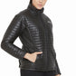 Woman wearing a black quilted Equine Couture Ladies Zima Jacket with hands in pockets, standing against white background