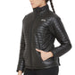 Woman wearing a black Equine Couture Ladies Zima Jacket with quilted design and zippered front pockets.
