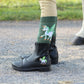 TuffRider Children's Unicorn Starter Front Zip Paddock Boots shown worn with unicorn socks near a horse's hoof.