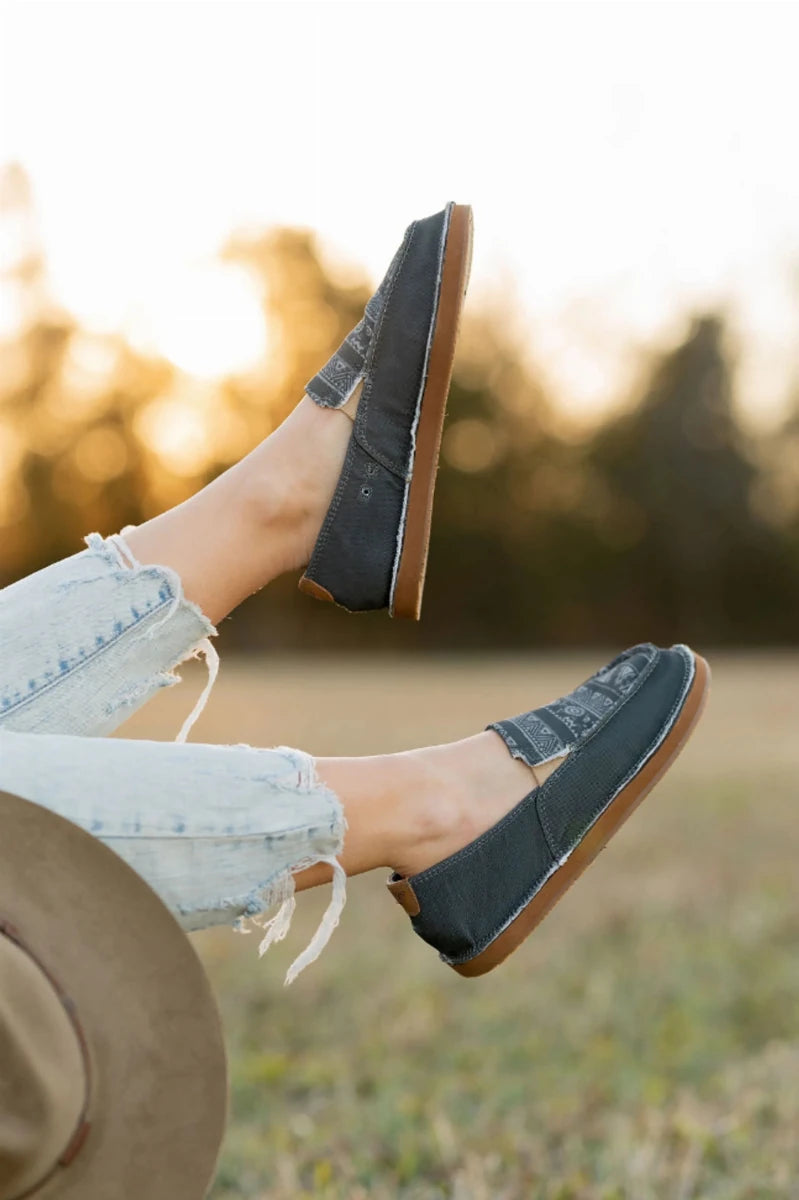 TuffRider Women's Slip-On Canvas Graphix Shoes - Memory Foam Equestrian Casual Shoes worn outdoors with light denim jeans