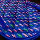 Quilted blue Lettia All Purpose Pad with pink and green dog silhouettes and adjustable straps on edges