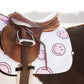 Lettia Smiley Quilted Pattern All Purpose Pad with smiley faces under a brown leather saddle on a black and white horse