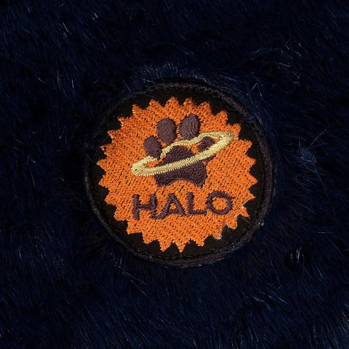 Close-up of a halo patch on the dark plush material of the Rectangular Dog Bed - Plush Cushioned Bed with Removable Washable Cover