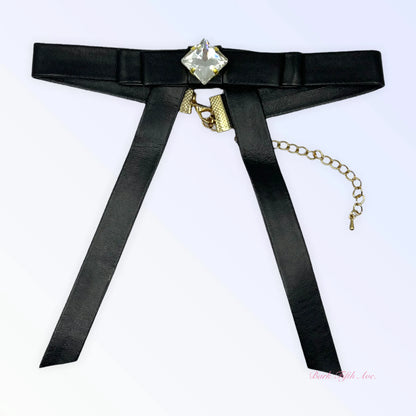 Black Vegan Leather Long Bow Necklace with gold chain and clear square gemstone centerpiece on white background