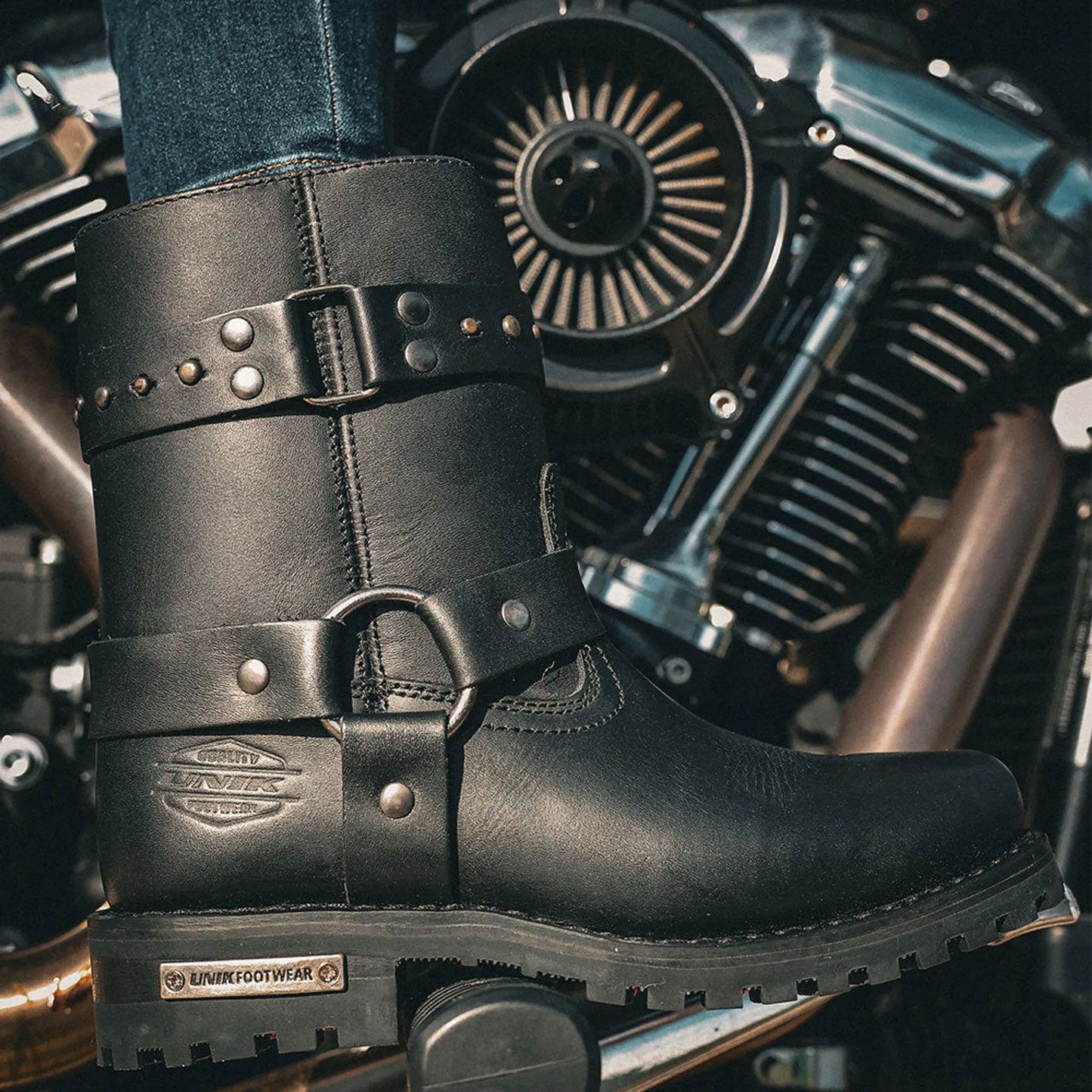12008.00 - Ladies Motorcycle Biker Leather Boots in black with buckles and stud details on a motorcycle footrest