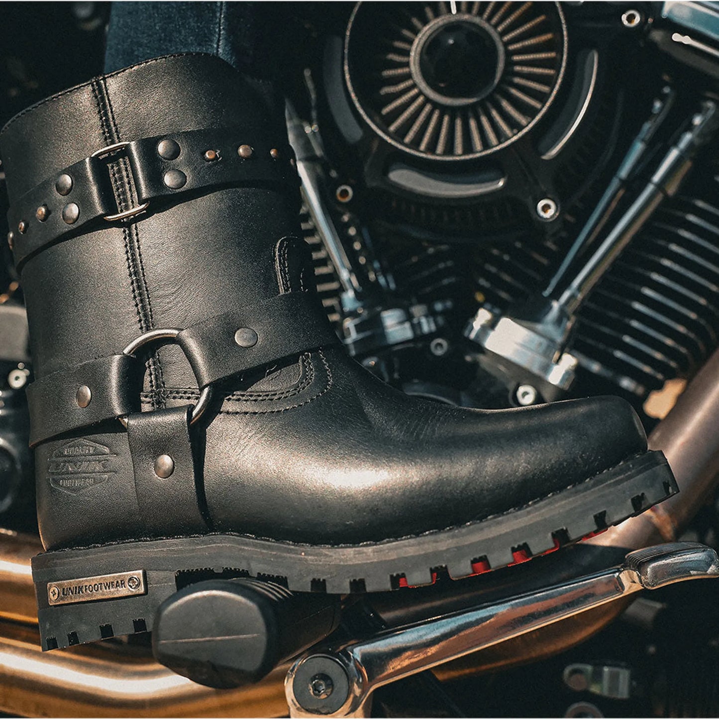 12008.00 - Ladies Motorcycle Biker Leather Boots in black with buckle and stud details on motorcycle footrest