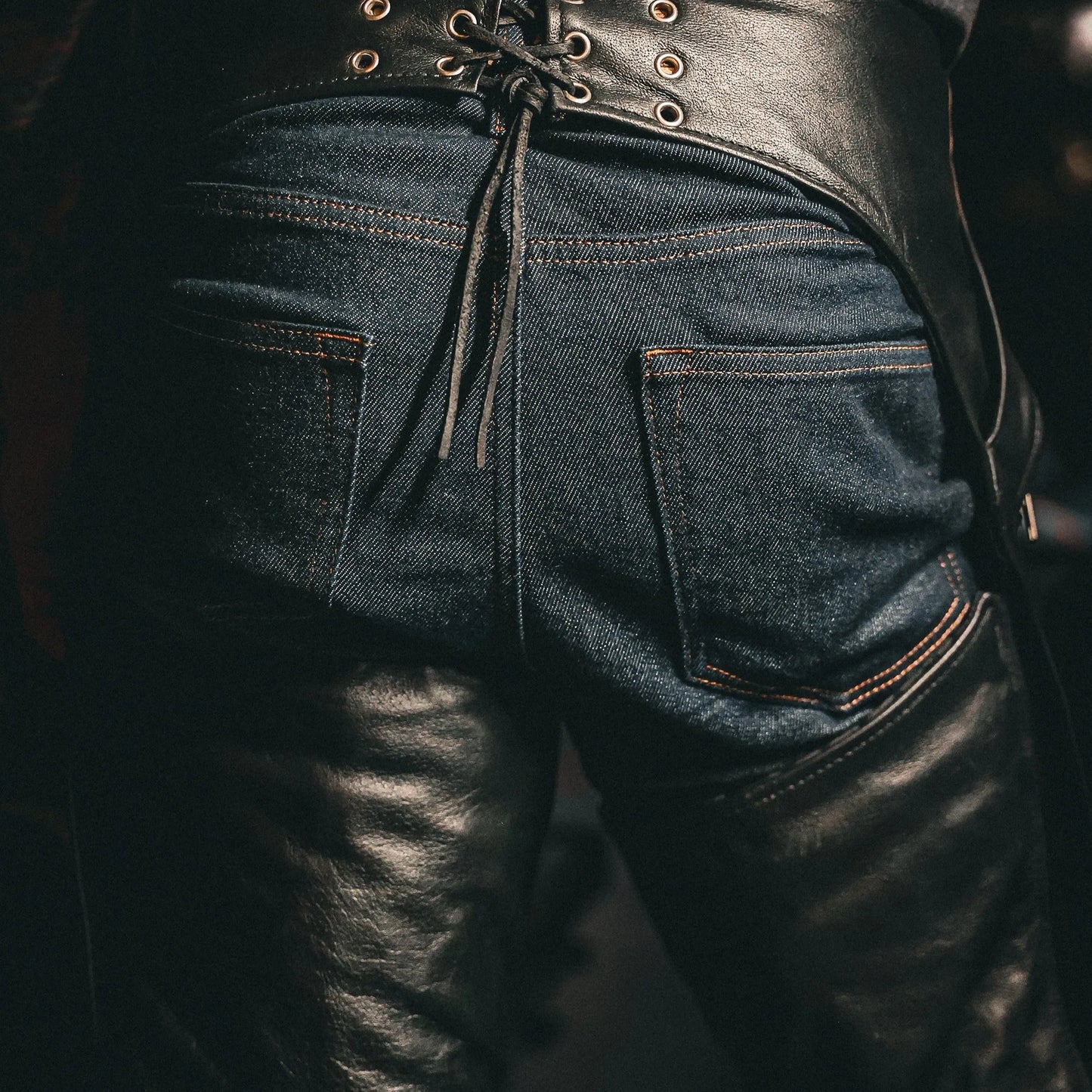 Close-up of black leather and denim sections on 6130.00 - Unisex Ultra 4-Pocket Chaps with Spandex designed for equestrian use.