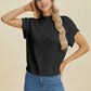 Model wearing a black Double Take Full Size Mock Neck Short Sleeve Sweater with jeans against a beige background