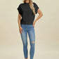 Woman wearing a black Double Take Full Size Mock Neck Short Sleeve Sweater with blue ripped skinny jeans and white sneakers.