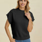 Woman wearing black Double Take Full Size Mock Neck Short Sleeve Sweater with ribbed details and blue jeans on beige background