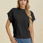Woman wearing a black Double Take Full Size Mock Neck Short Sleeve Sweater paired with blue jeans against beige background