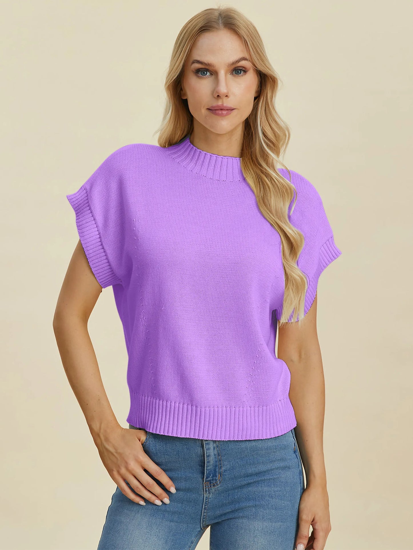 Woman wearing a lavender Double Take Full Size Mock Neck Short Sleeve Sweater with jeans against neutral background