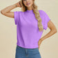 Woman wearing lavender Double Take Full Size Mock Neck Short Sleeve Sweater with jeans posing against beige background
