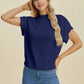 Woman wearing navy Double Take Full Size Mock Neck Short Sleeve Sweater paired with blue jeans against beige background