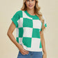 Woman wearing a green and white Double Take Full Size Checkered Round Neck Short Sleeve Sweater with jeans, smiling.