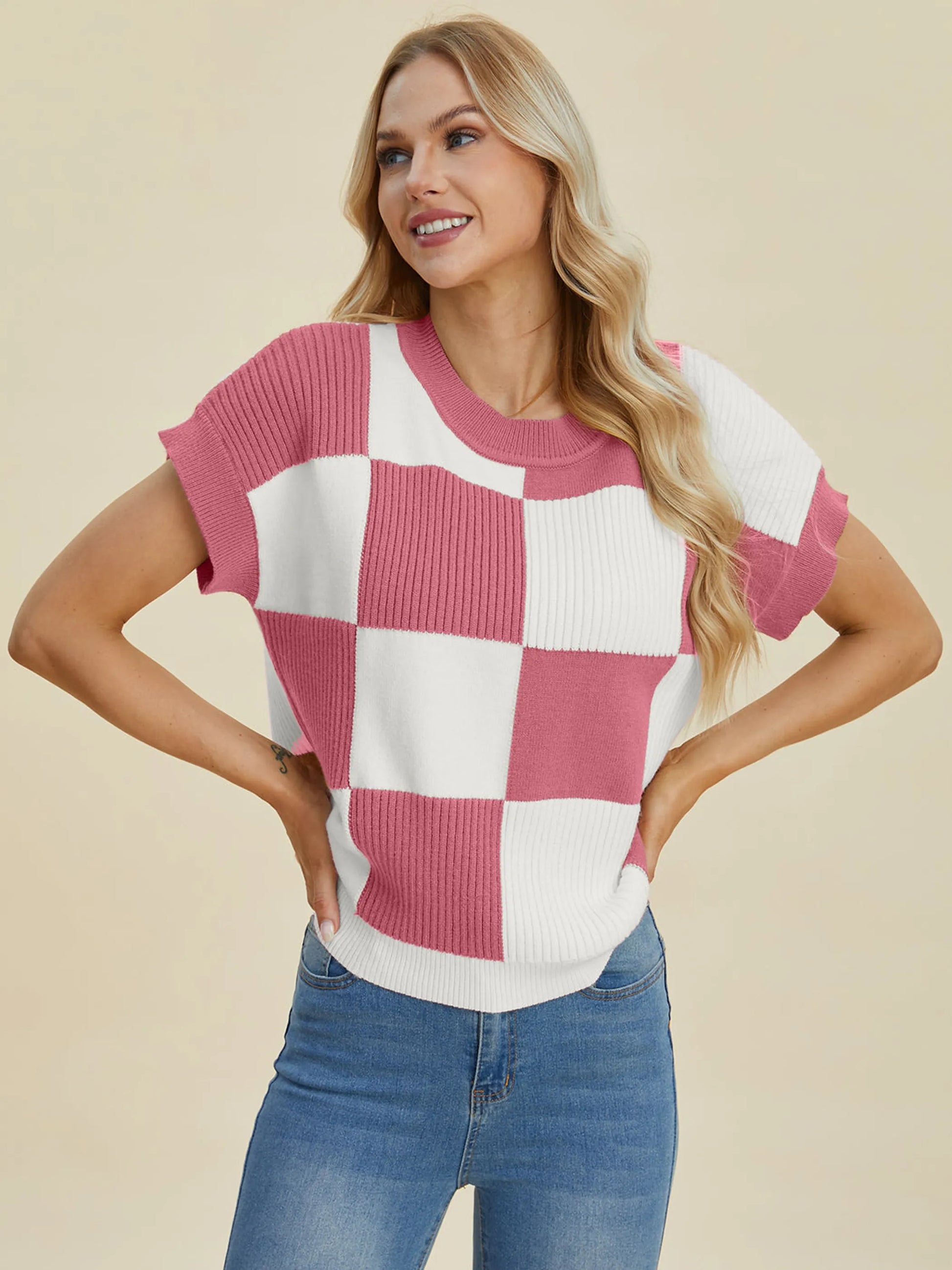 Woman wearing a pink and white checkered knit top in Double Take Full Size Checkered Round Neck Short Sleeve Sweater