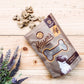 Package of Kaiser's Favorites Dog Treats with heart-shaped treats on wooden surface beside lavender flowers