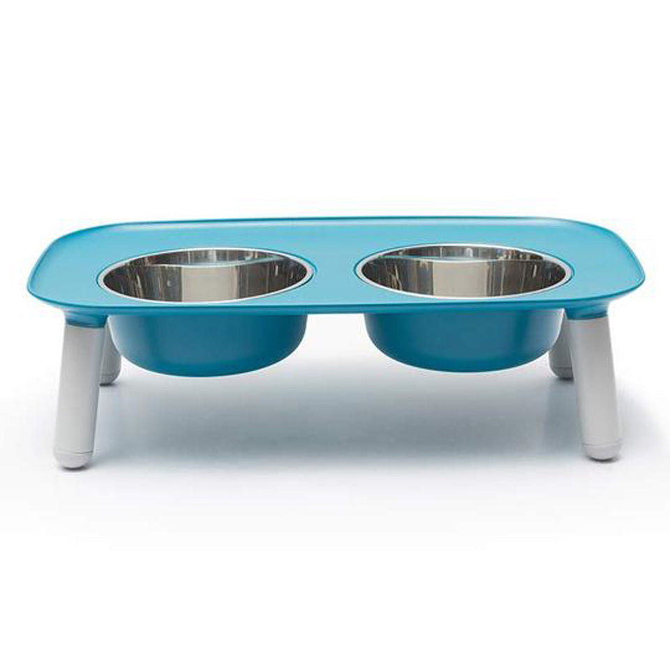 Elevated teal stand with four legs holds two stainless steel feeding bowls